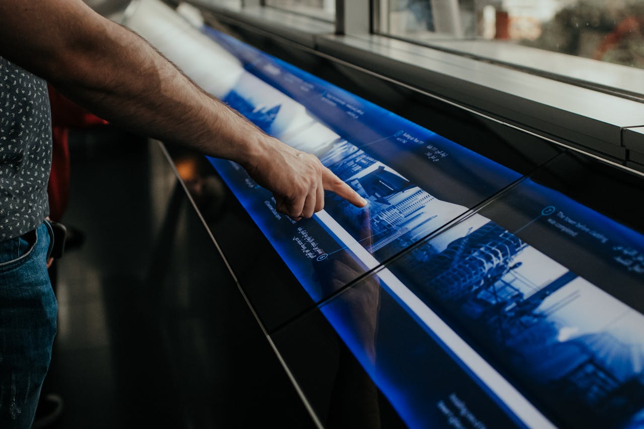 our-story Close-up of a person interacting with a touchscreen display in a modern environment.